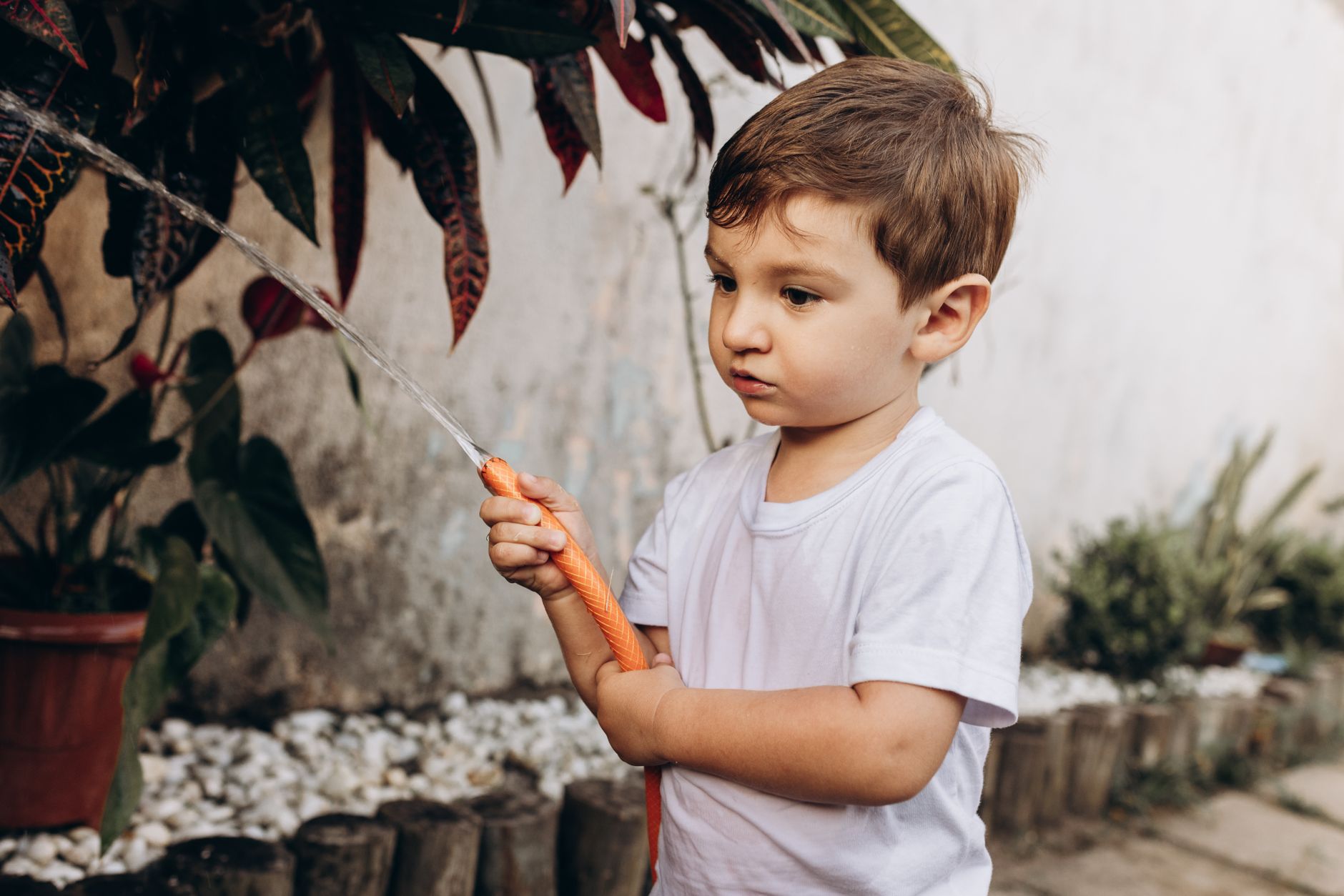Children planting seeds in a garden container, exploring gardening activities for kids outdoors