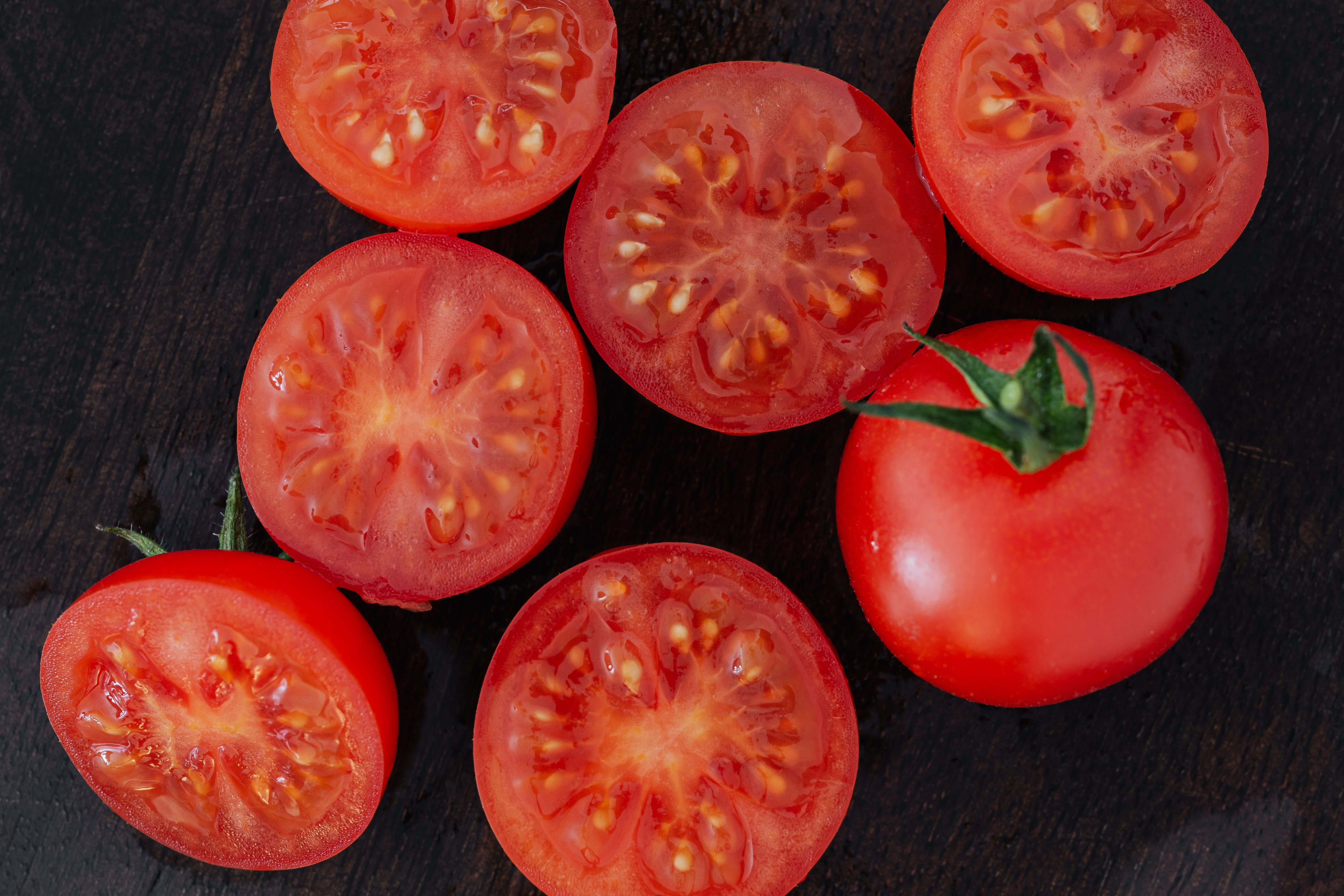 Early Girl tomato plants growing in a home garden with ripe red fruit ready for harvest
